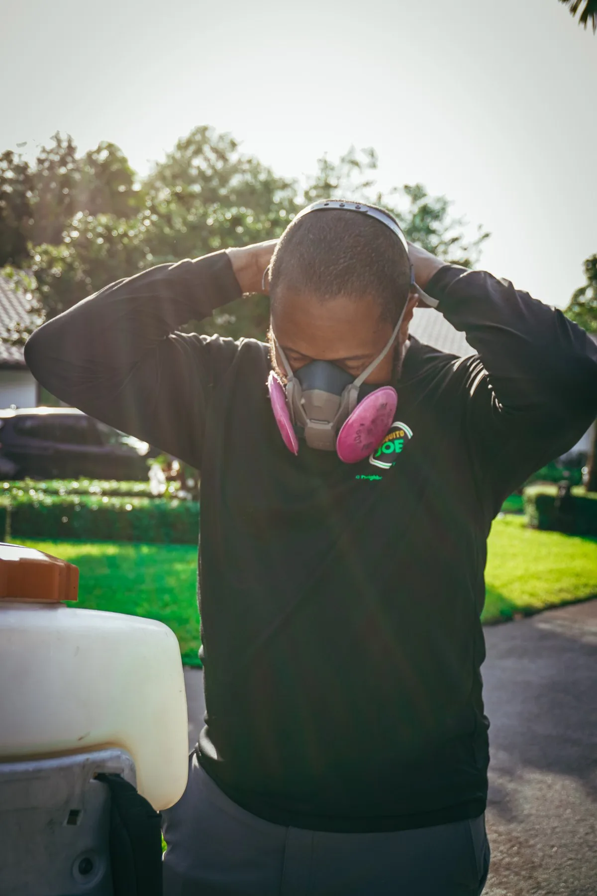 A technician putting on a respirator